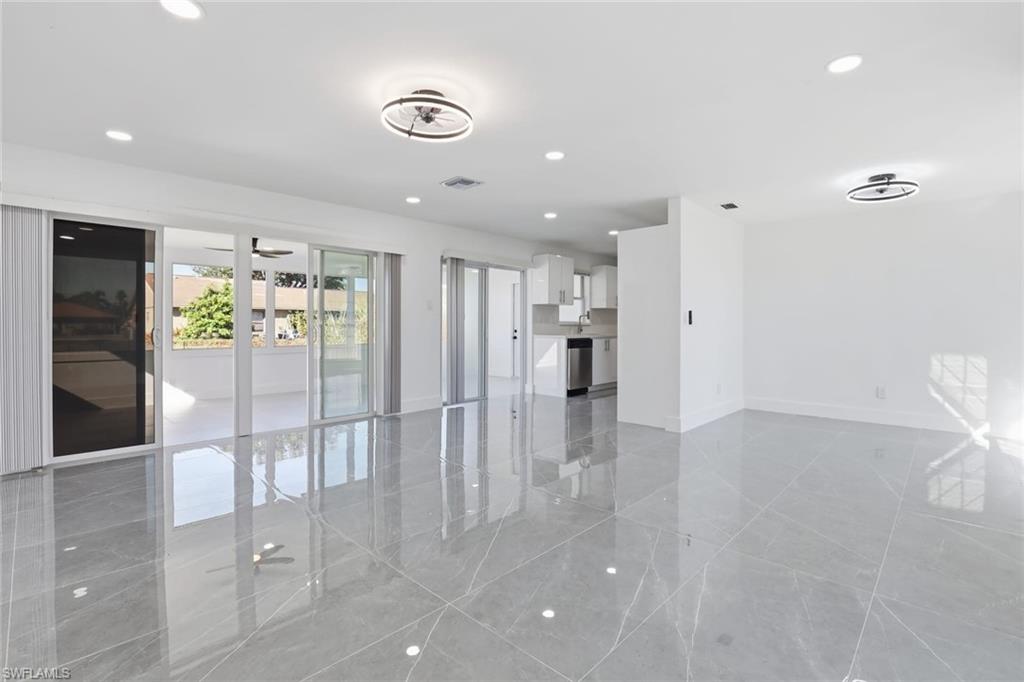 Unfurnished living room with recessed lighting and baseboards