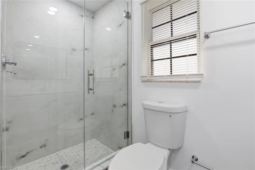 Bathroom featuring toilet and a stall shower