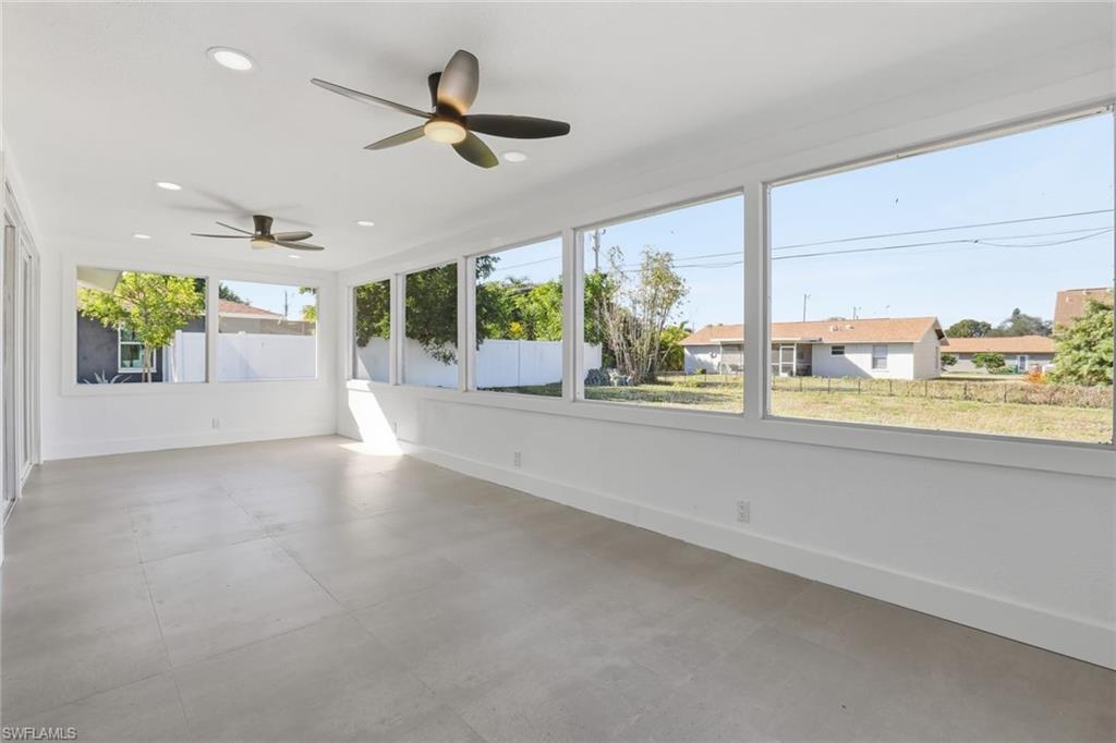 Unfurnished sunroom featuring a ceiling fan