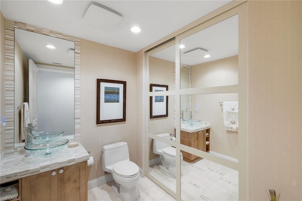 Fourth full bathroom with a hidden tub & shower beyond the sliding mirror wall.