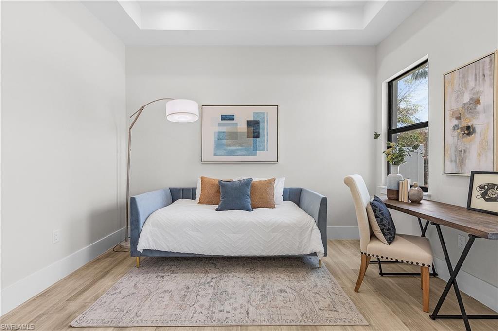 Bedroom featuring a raised ceiling and light wood-style floors