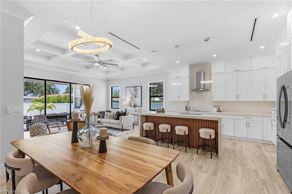 Dining area featuring coffered ceiling, light wood-style flooring, ceiling fan, plenty of natural light, and recessed lighting