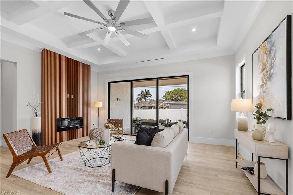 Living area with coffered ceiling, ceiling fan, light wood-style floors, and recessed lighting