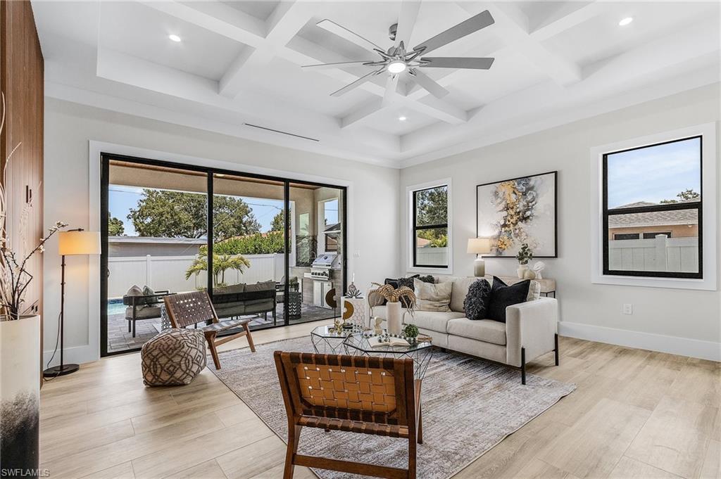 Living area with a ceiling fan, coffered ceiling, light wood-style flooring, and recessed lighting
