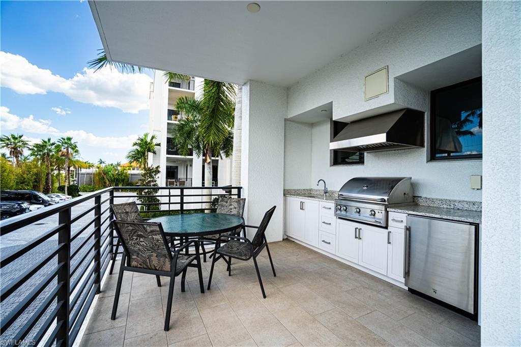 Balcony featuring an outdoor kitchen / dining area and a sink