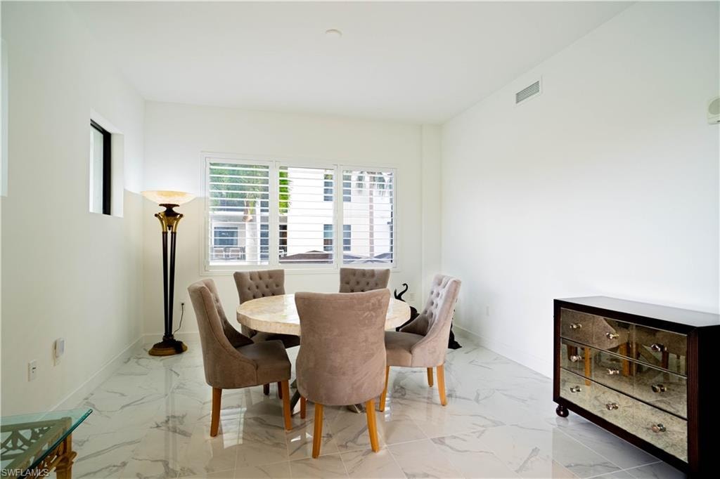Dining area featuring light marble finish flooring and baseboards