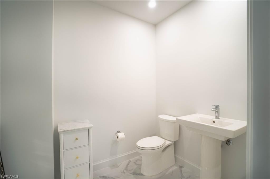 Half bathroom with recessed lighting and marble finish floorin
