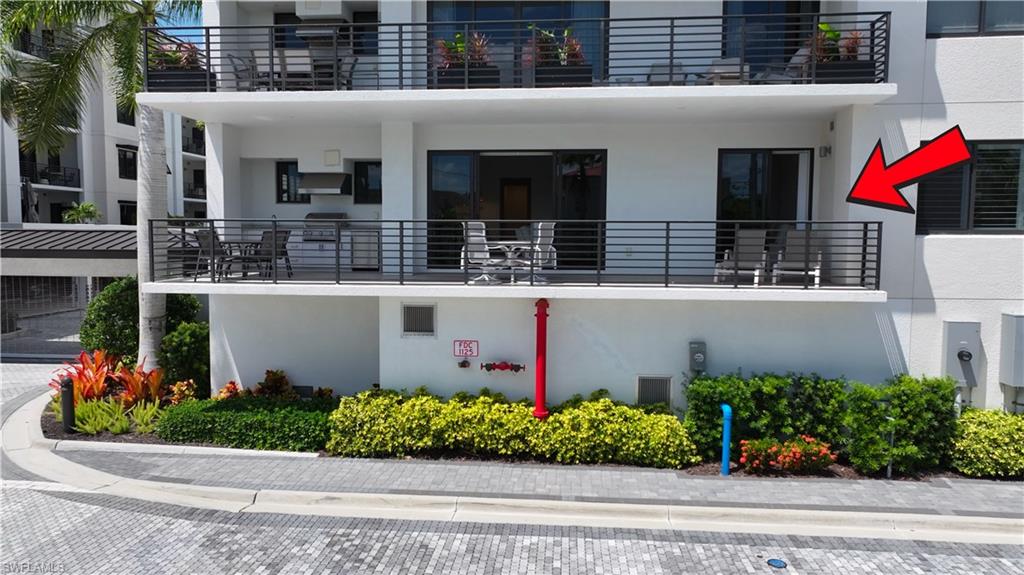 Upper-level balcony featuring contemporary horizontal metal railings, built-in outdoor grill station, and glass sliding door access