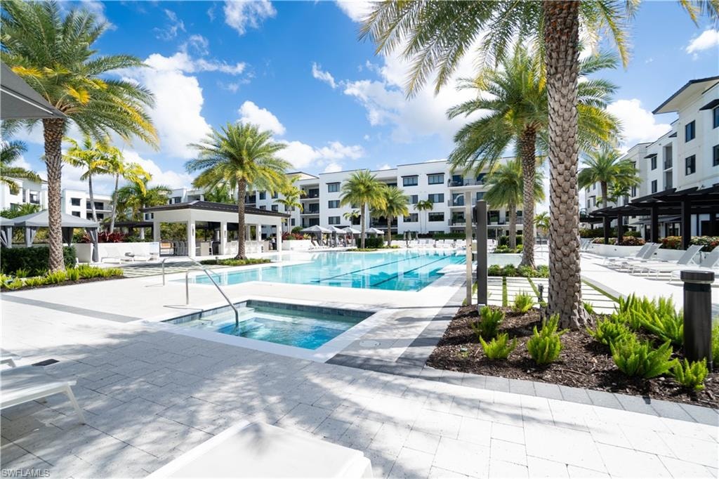 Expansive outdoor amenity space featuring a large swimming pool, integrated spa, and spacious paver patio