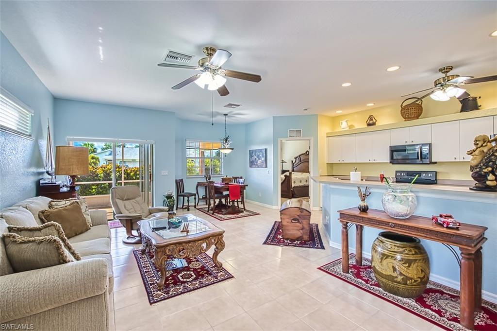 Living room with ceiling fan, recessed lighting, and light tile patterned floors