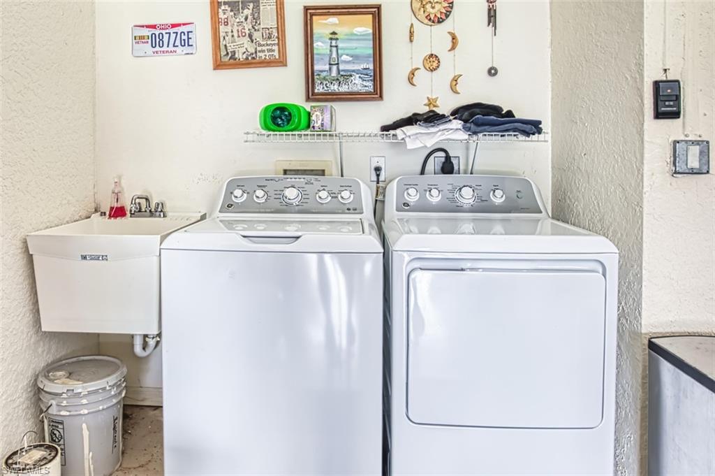 Laundry room with a textured wall and independent washer and dryer