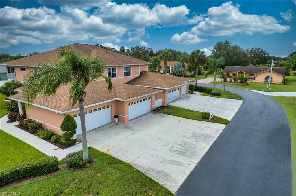 View of front of home with driveway, a garage, a front lawn, stucco siding, and a shingled roof