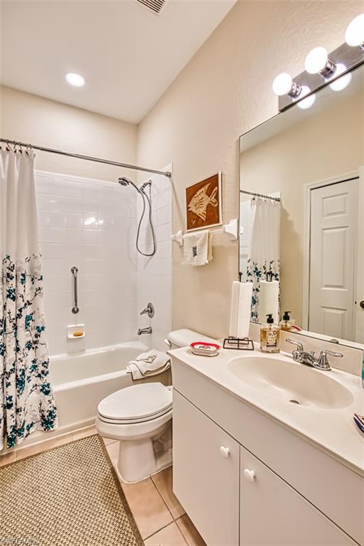 Full bathroom featuring vanity, light tile patterned floors, and shower / bathtub combination with curtain