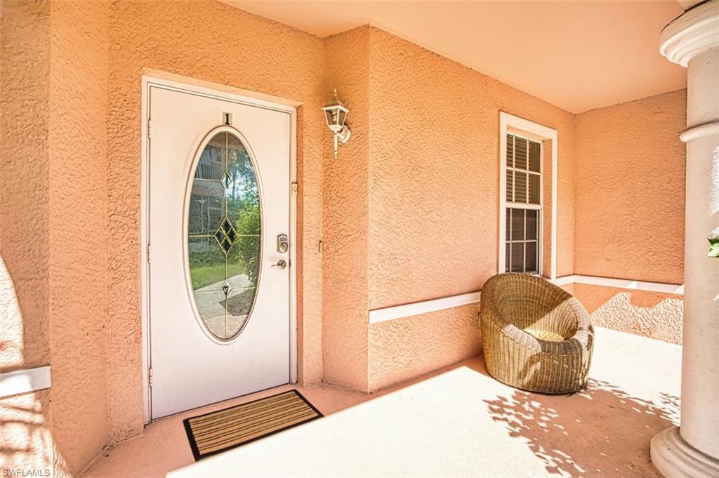 Entrance to property with stucco siding and a porch
