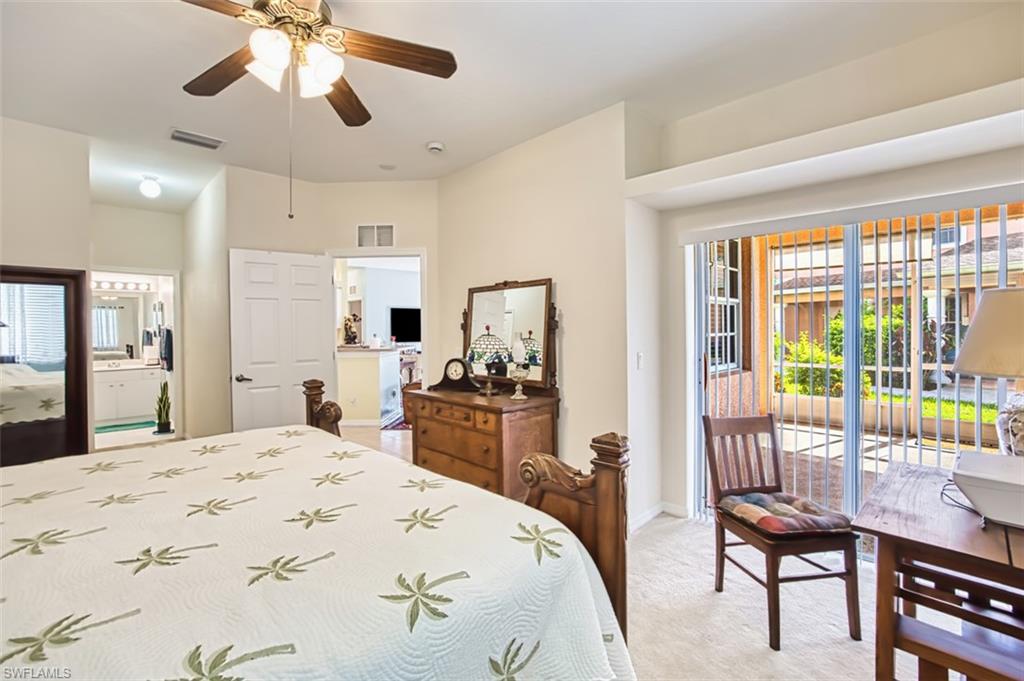 Bedroom with access to exterior, light carpet, ceiling fan, and ensuite bathroom