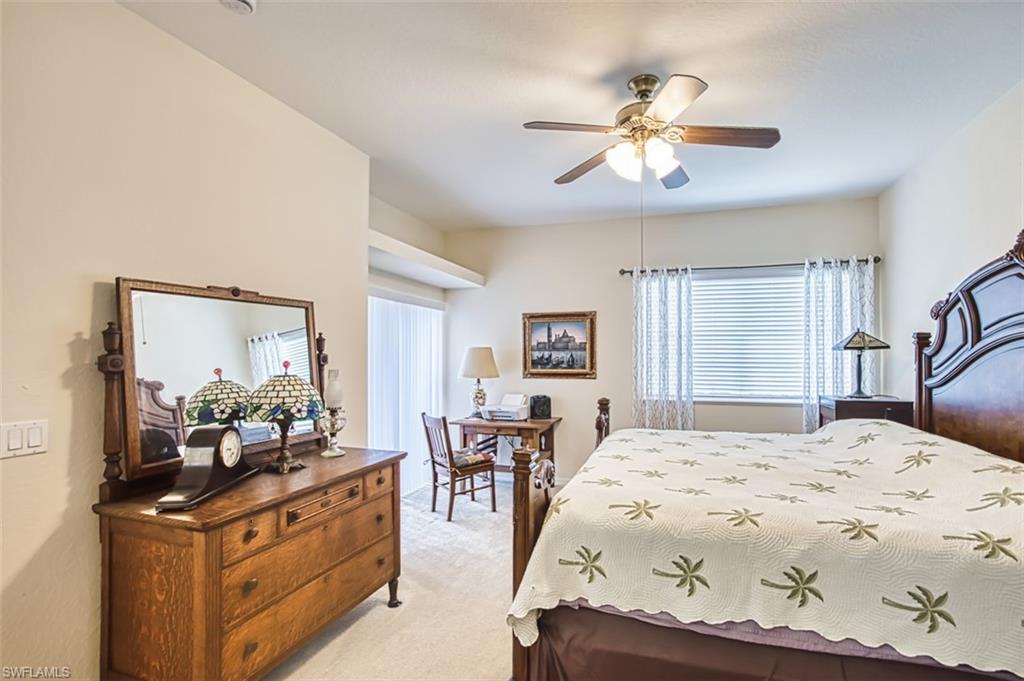 Bedroom featuring light carpet, multiple windows, and ceiling fan