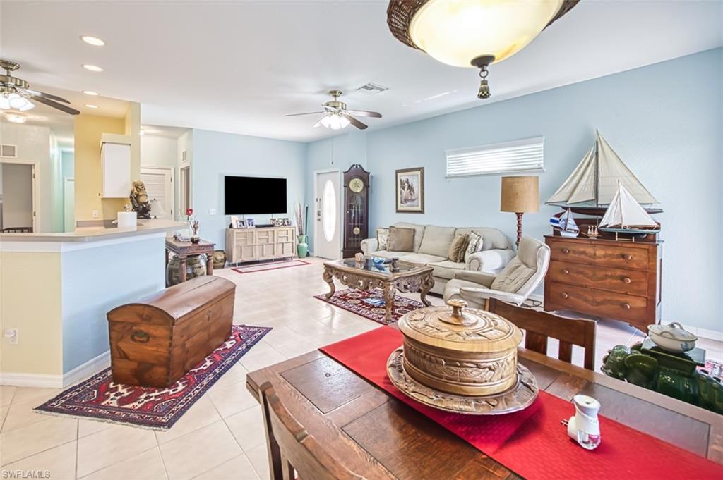 Living area featuring ceiling fan, light tile patterned floors, and recessed lighting