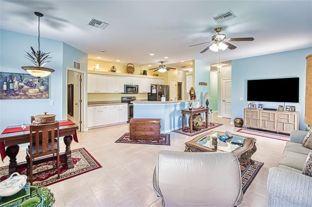 Living room featuring ceiling fan, light tile patterned floors, and recessed lighting