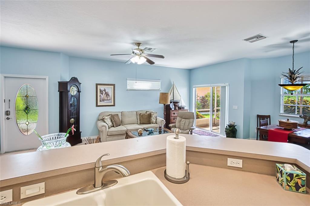 Kitchen with light countertops, open floor plan, pendant lighting, and ceiling fan