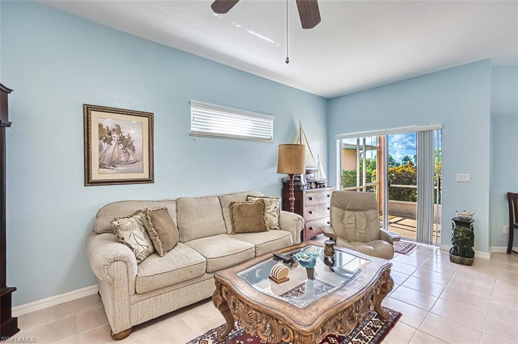 Living area with ceiling fan and light tile patterned flooring