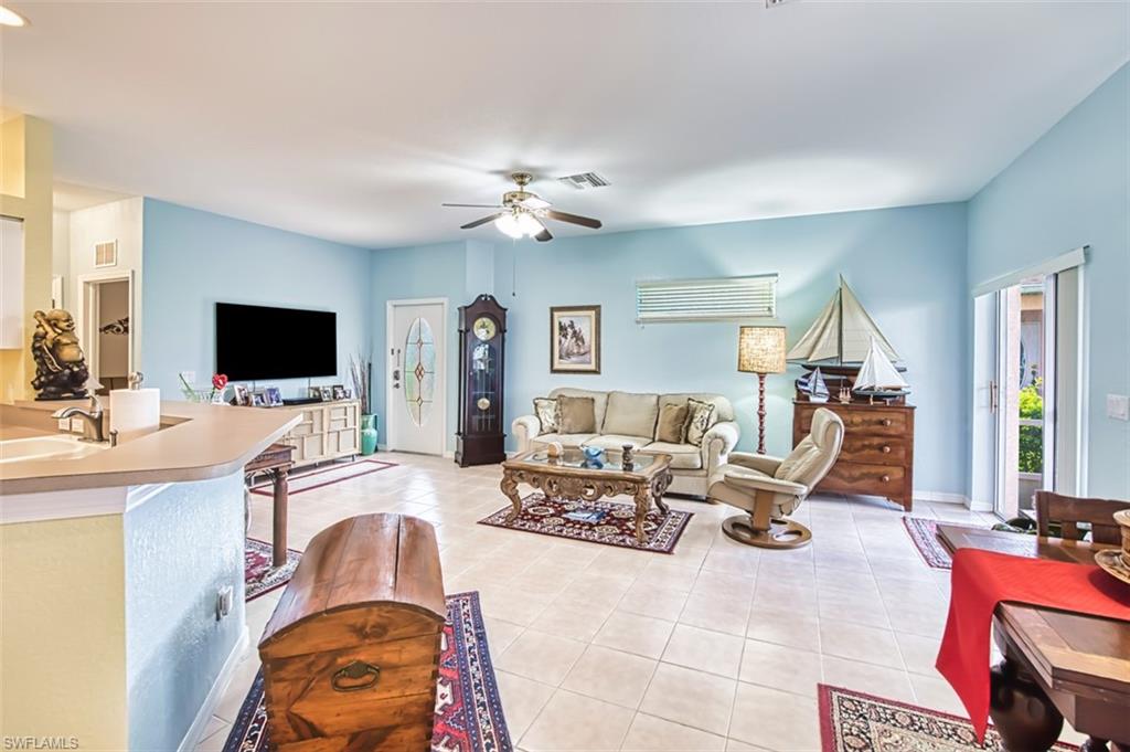 Living area featuring light tile patterned floors and a ceiling fan