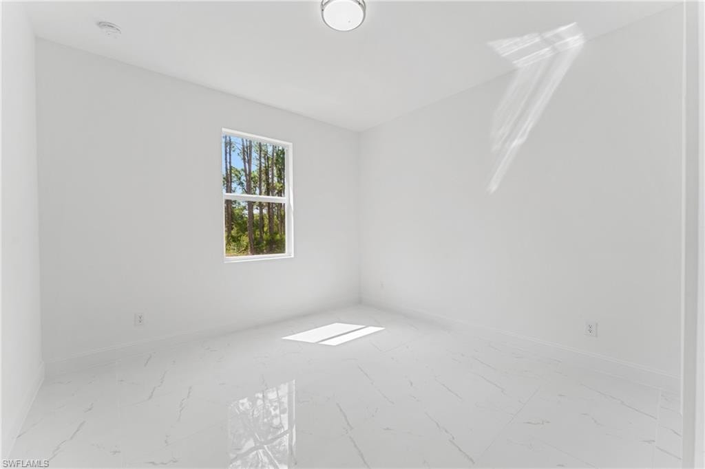 Unfurnished room with marble finish floor and baseboards