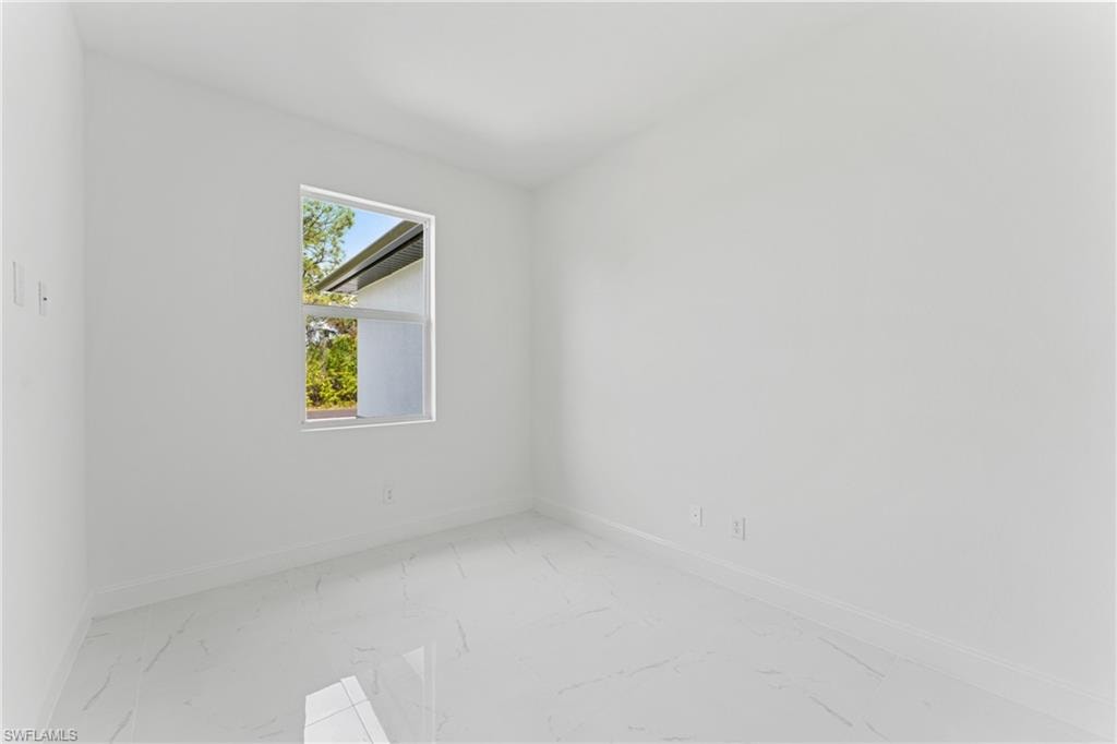Empty room featuring marble finish floor and baseboards