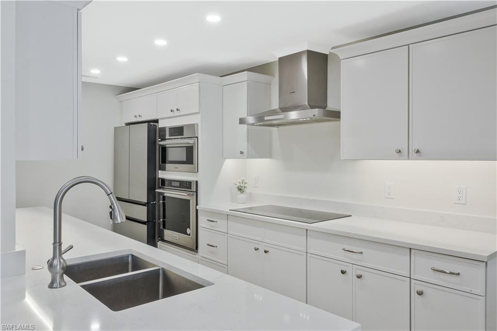 Kitchen featuring white cabinets, recessed lighting, light stone countertops, and stainless steel appliances