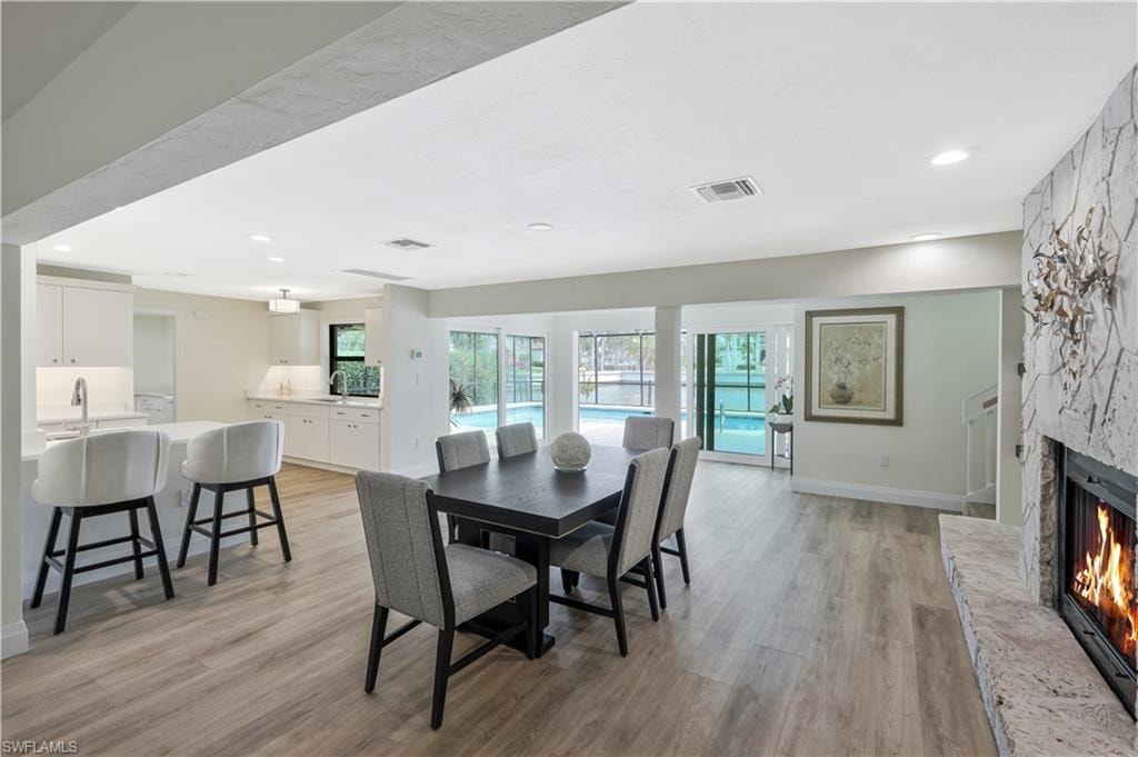 Dining area with a fireplace, recessed lighting, and light wood-style floors