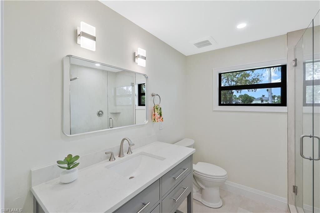 Bathroom featuring vanity, a stall shower, and recessed lighting