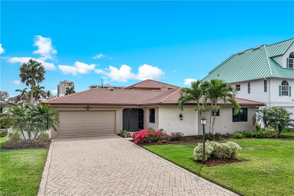 View of front of home with a front lawn, a garage, decorative driveway, and stucco siding