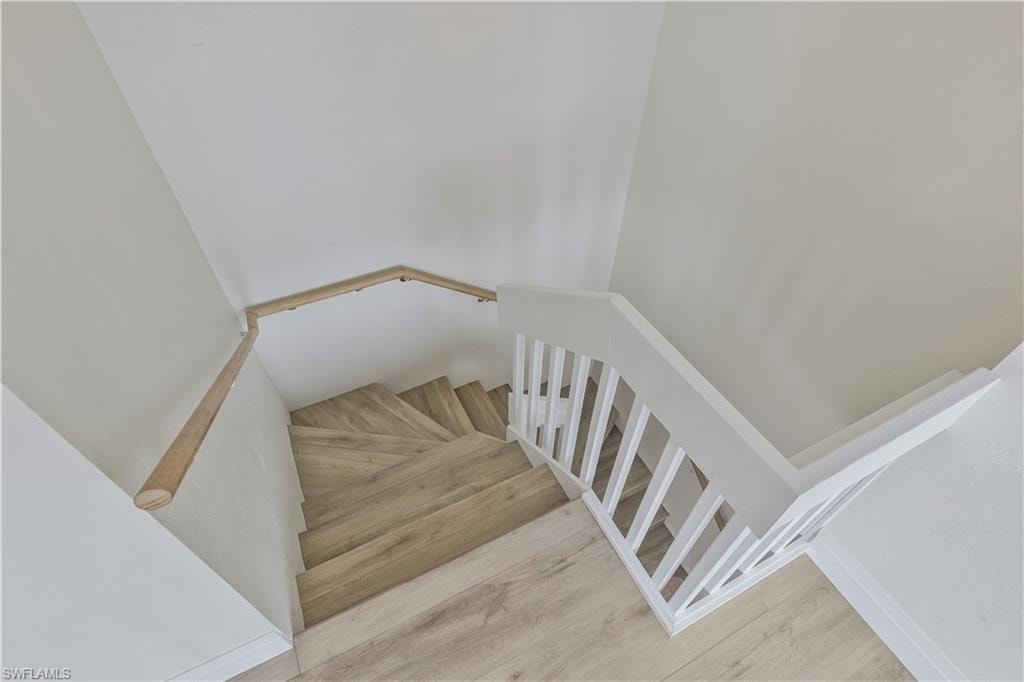 Stairway featuring wood finished floors