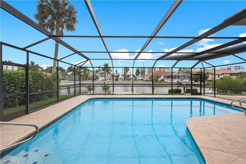 Outdoor pool featuring a sunroom, a lanai, a residential view, a water view, and a patio area