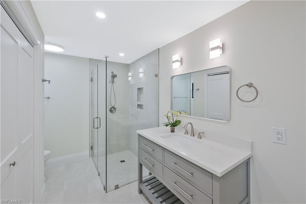 Full bathroom featuring vanity, a shower stall, and recessed lighting