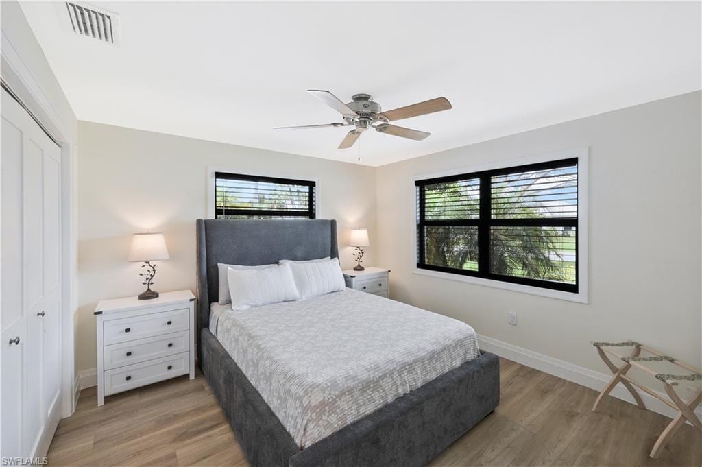 Bedroom with light wood-style floors, ceiling fan, and a closet