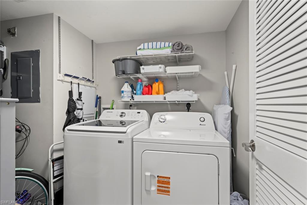 Laundry room with electric panel and washing machine and clothes dryer