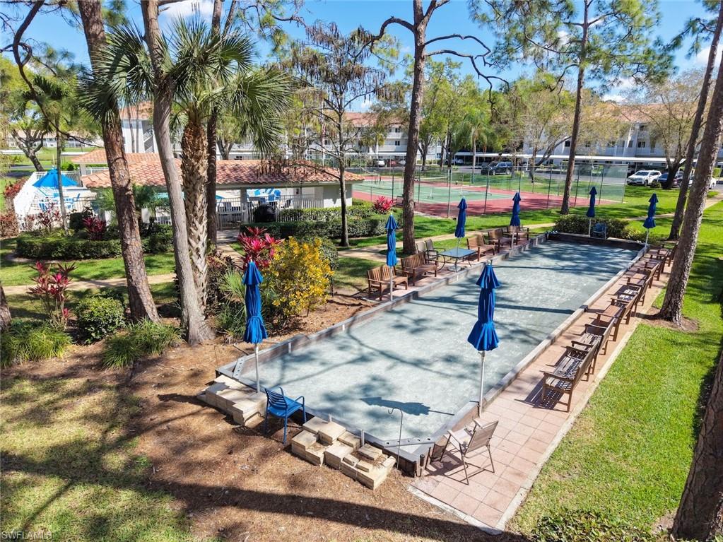 View of property's community with a game area, a patio, and a tennis court