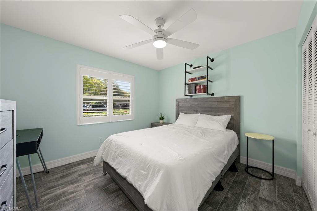 Bedroom with wood tiled floors, a closet, and ceiling fan