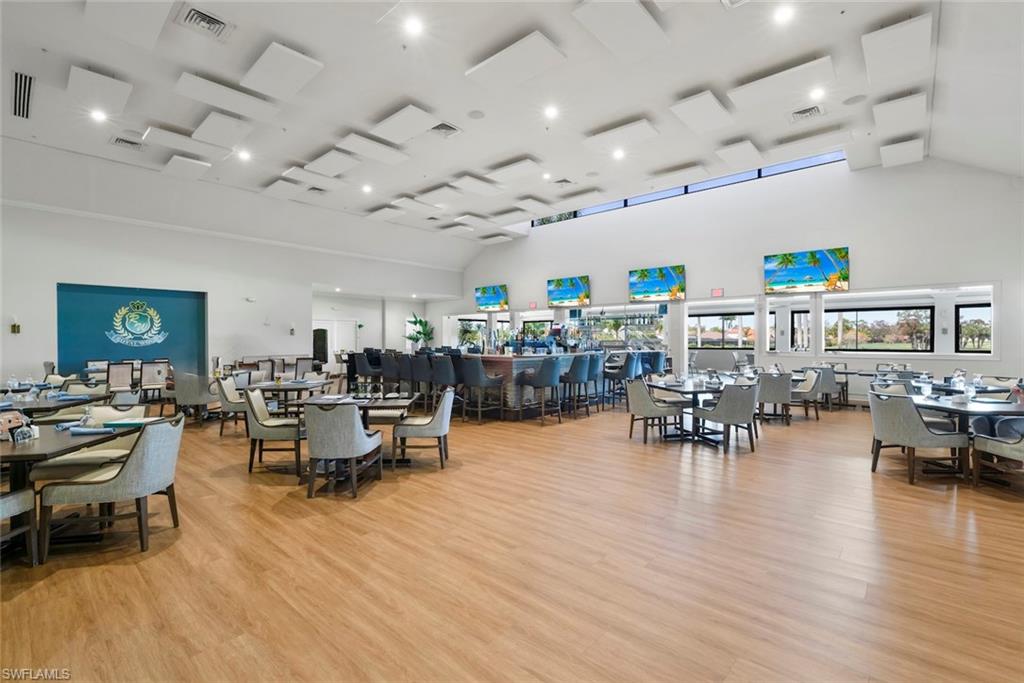 Dining space with light wood-style floors, lofted ceiling, and recessed lighting