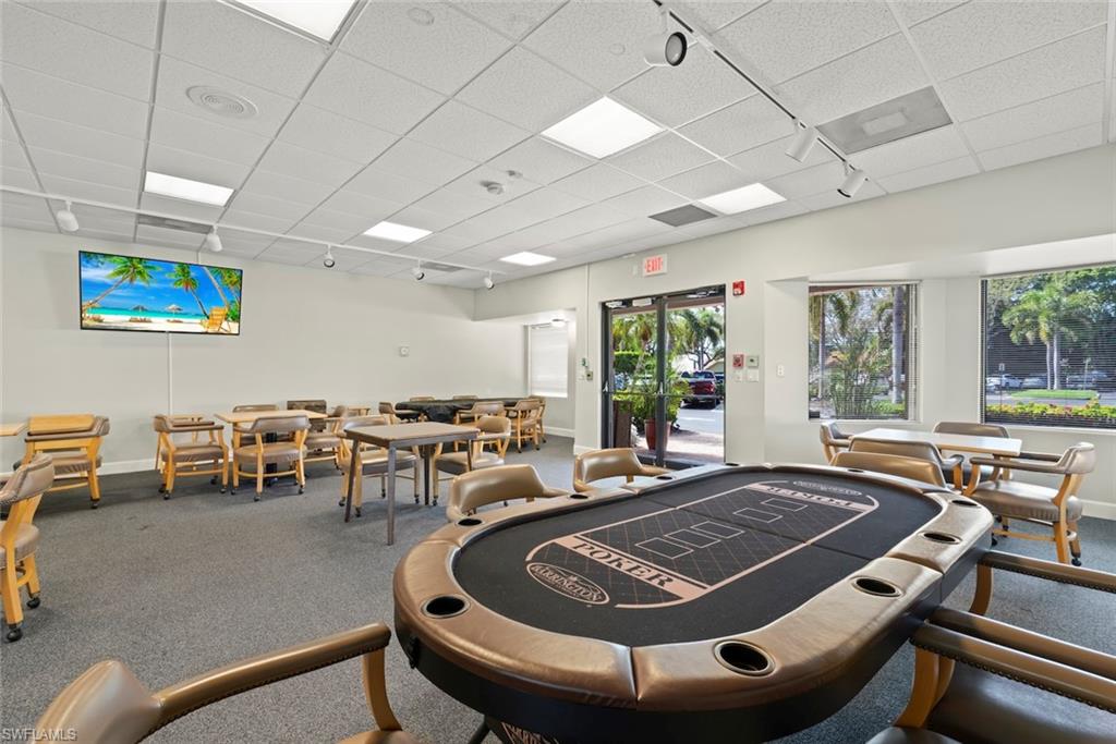 Recreation room with rail lighting and a paneled ceiling