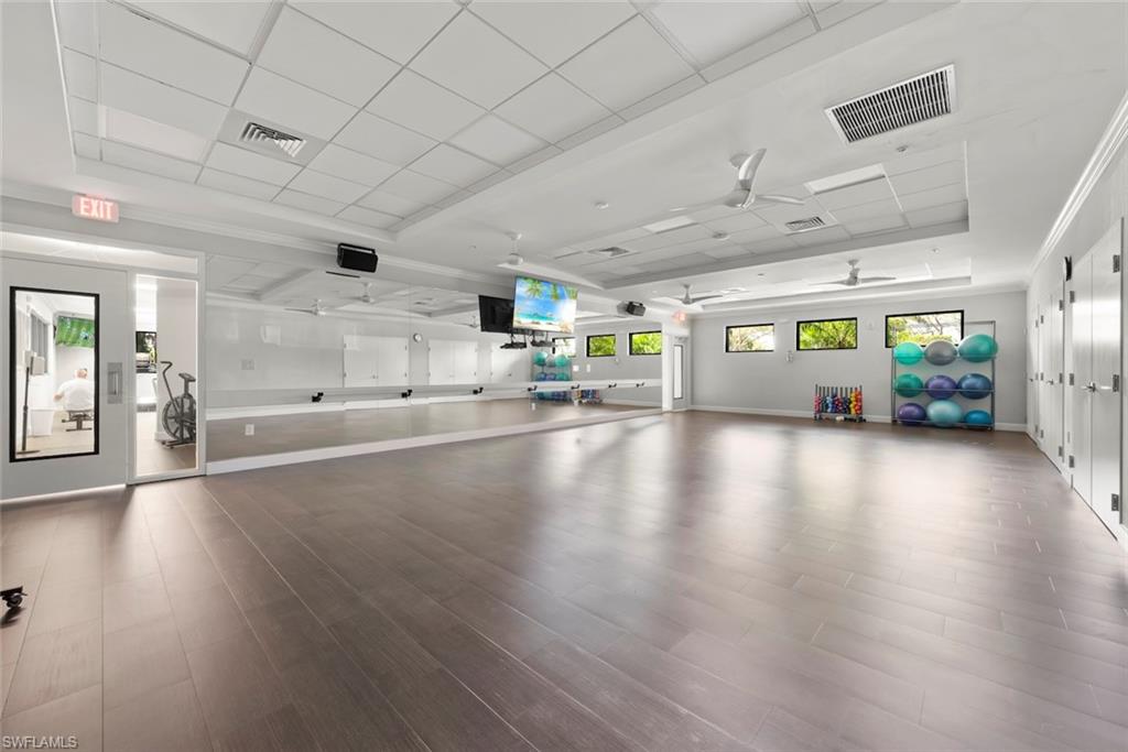 Miscellaneous room with ceiling fan, a paneled ceiling, a raised ceiling, and crown molding