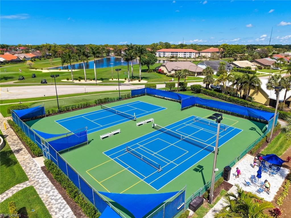 View of tennis court with a water view
