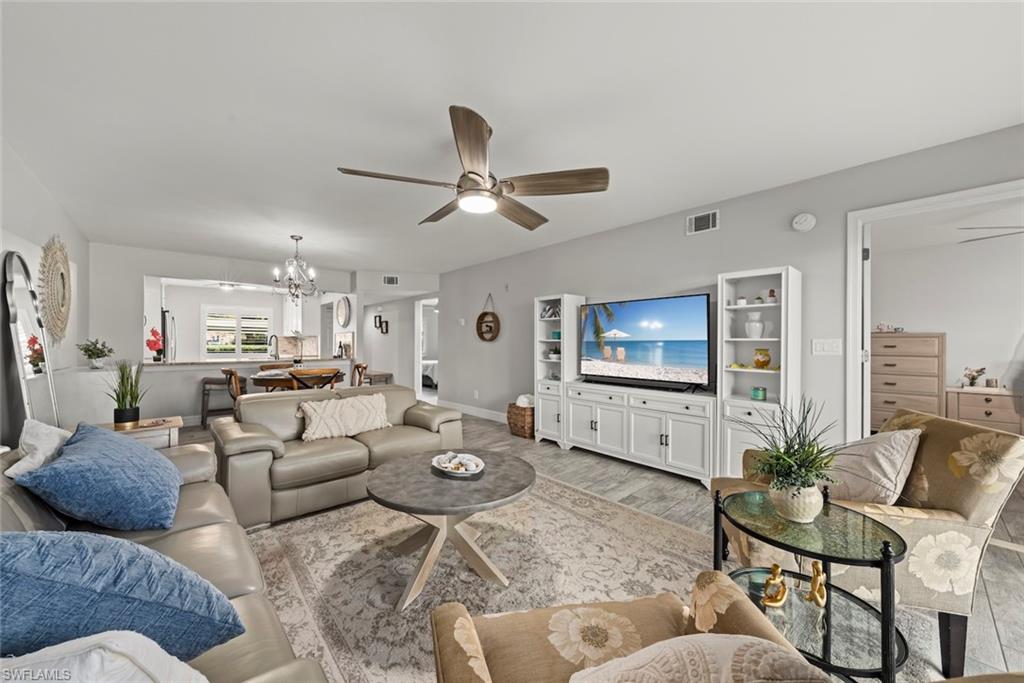 Living area featuring a chandelier, a ceiling fan, and wood finished floors