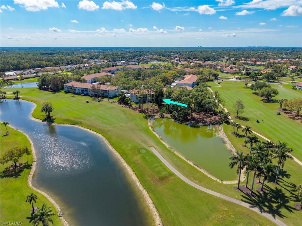 Drone / aerial view of a golf course and a nearby body of water