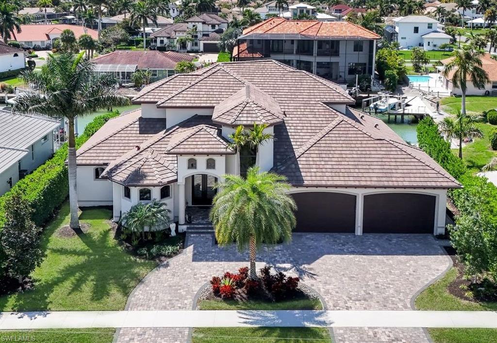 View of front of home with a tile roof, decorative driveway, an attached garage, and stucco siding