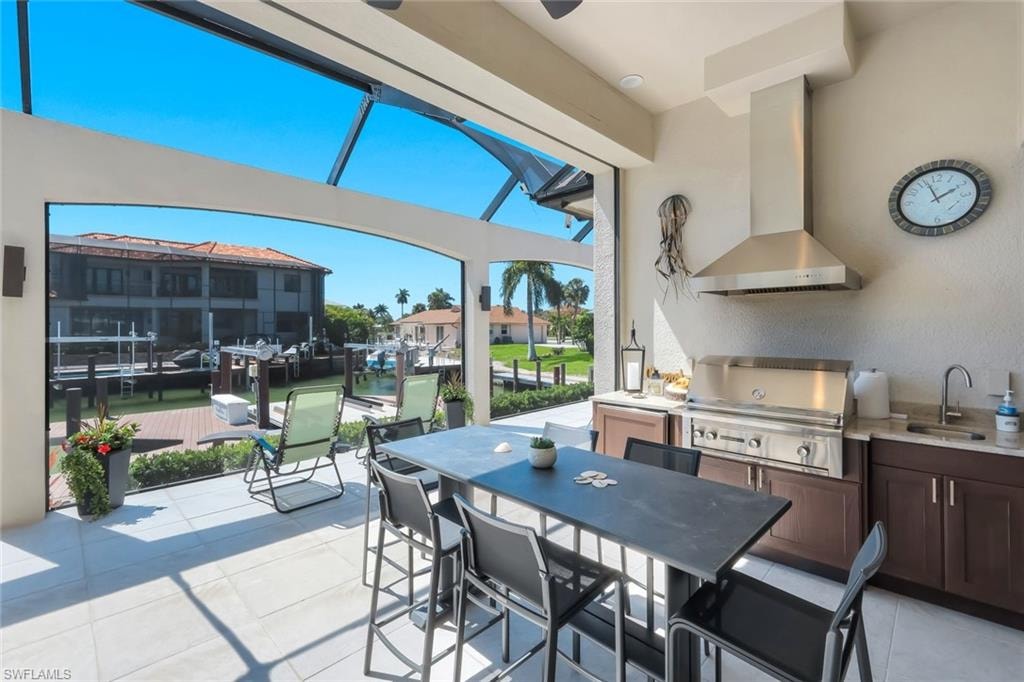 View of patio featuring a sunroom, an outdoor kitchen / dining area, and a residential view