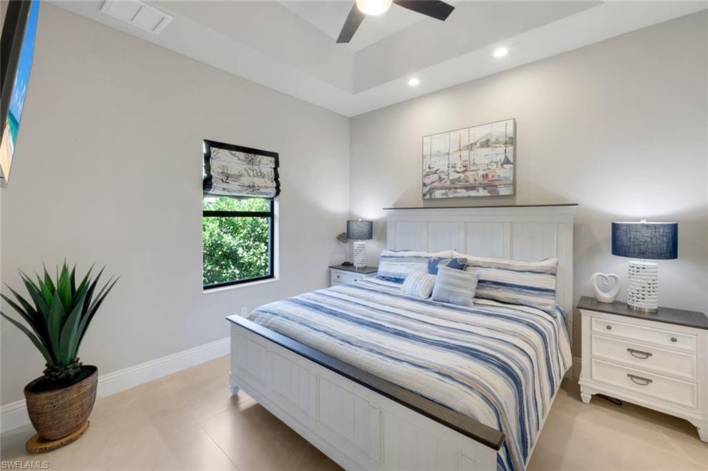 Bedroom featuring ceiling fan, recessed lighting, and a tray ceiling