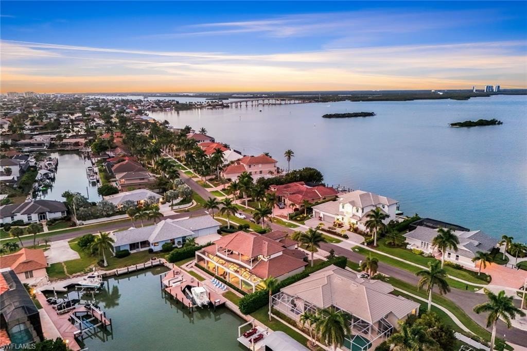 Aerial view of residential area with a nearby body of water and a notable bridge
