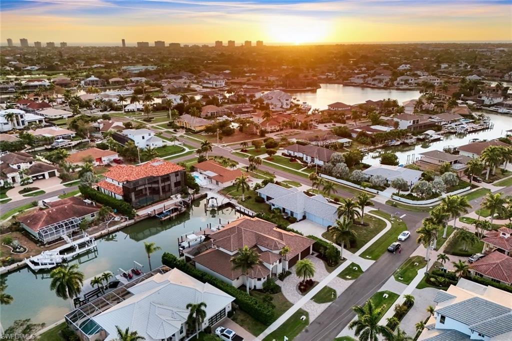 Aerial view at dusk of a water view, a residential view, and a skyline view