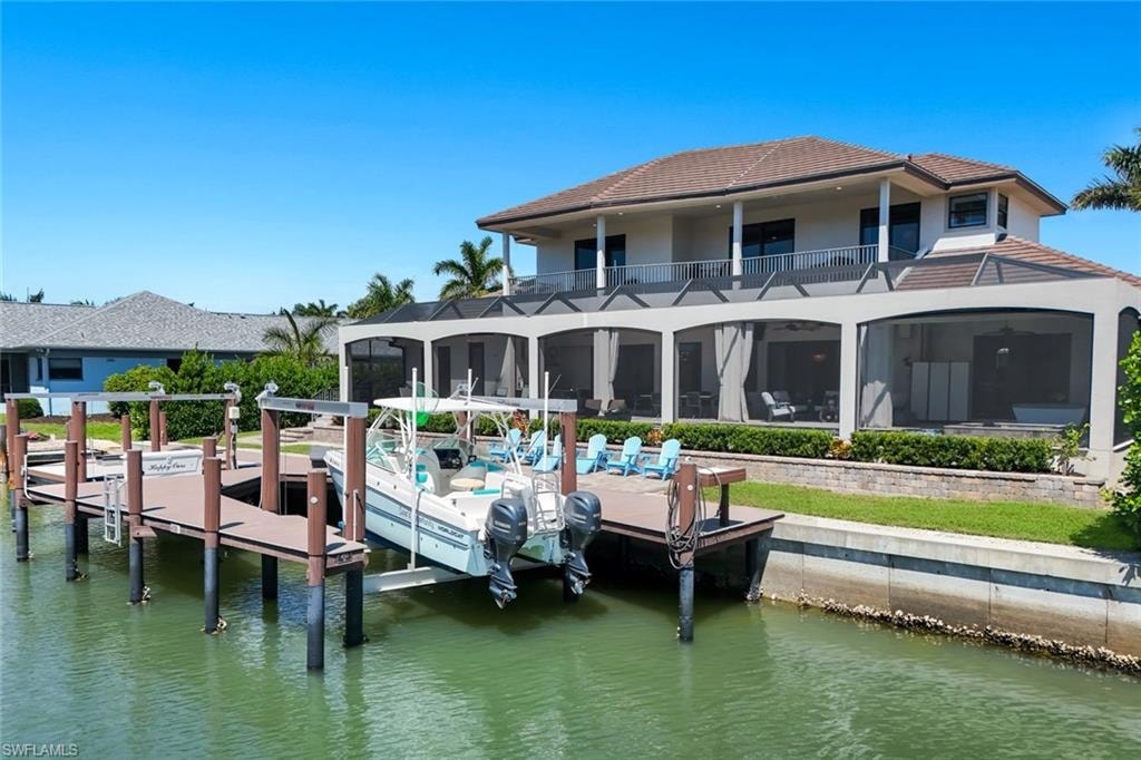 Dock area with a water view and a sunroom